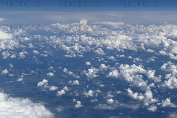 Aerial view from an aeroplane at high altitude of many white, bright cluster clouds Altocumulus,