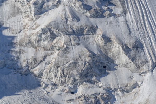 Intricate patterns of ice and rock are showcased in this stunning glacial landscape, revealing the