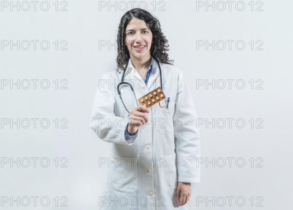 Female doctor holding pills tablet isolated. Portrait of a young female doctor showing pills tablet