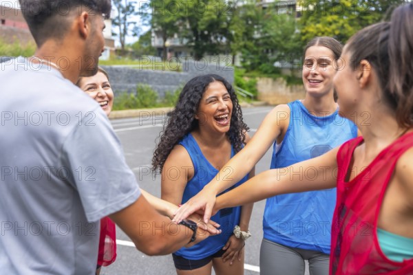 Young soccer players are gathering in a circle, joining their hands together, symbolizing their