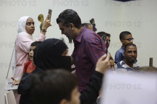 A Syrian puppeteer entertains children at the Damascus International Fair by imitating the role of