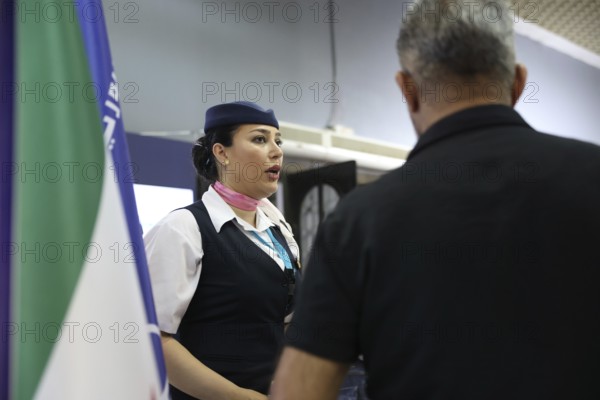A flight attendant from Syrian Airlines speaks with visitors at the Damascus International Fair.