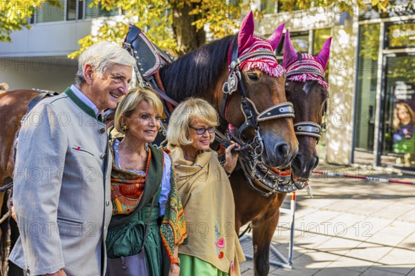 Actress Uschi Glas with man Dieter Hermann and wine tent landlady Doris Kuffler in front of a