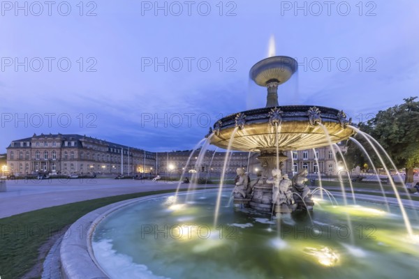Evening atmosphere at Schlossplatz Stuttgart. View of the New Palace. Illuminated fountain bowl at