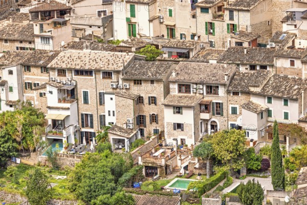 View at old idyllic residential houses with lush green gardens on an old village from an aerial