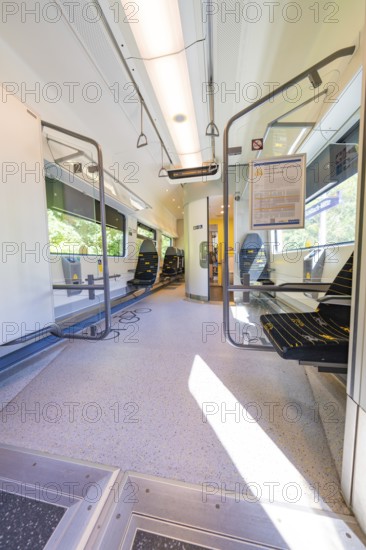 Large, bright interior of a train with wide windows, battery Electric train with green electricity,