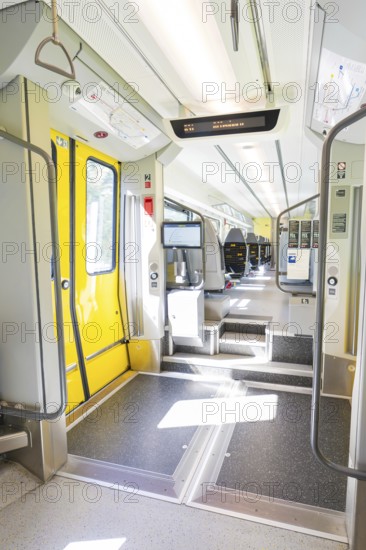 Modern entrance in the train with yellow doors and brightly lit interior, battery Electric train