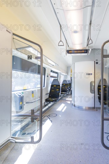 Modern and bright train interior with empty seats and lighting, battery Electric train with green