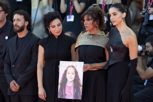 Venice, Italy - 3 September 2025: Kaouther Ben Hania (2vR) and Saja Kilani (R) with a portrait of