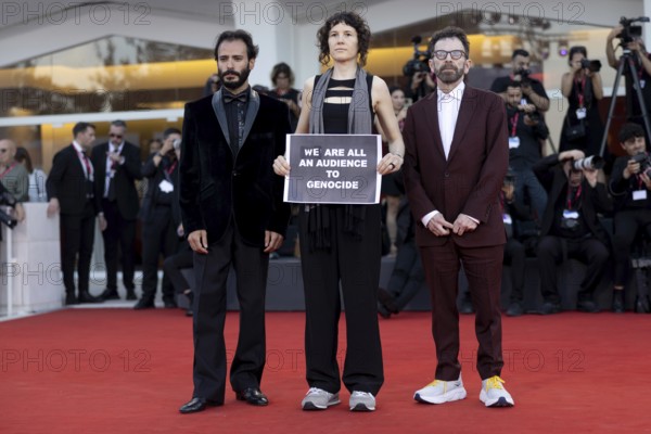 Venice, Italy - 1 September 2025: Charlie Kaufman, Eva H.D. and Josef Akiki with a sign reading -