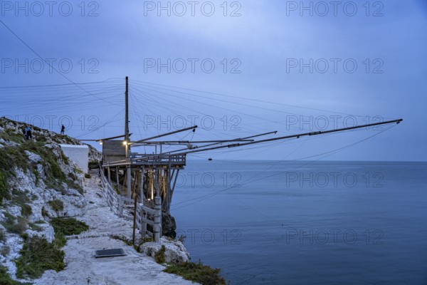 Historic pile dwelling of the fishermen Trabucco on the coast of Vieste at dusk, Gargano, Apulia,