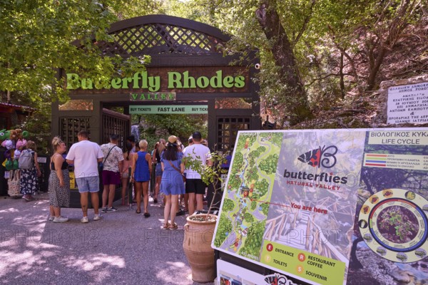 Entrance to a nature park full of butterflies with visitors and park sign, Butterfly Valley,