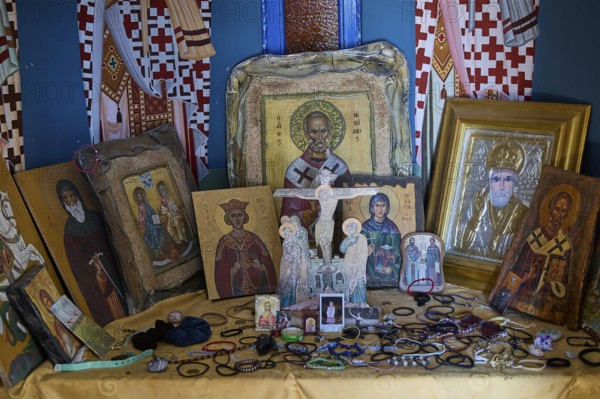 Table full of orthodox icons of various saints in an interior, Agios Nikolaos Chapel, harbour,