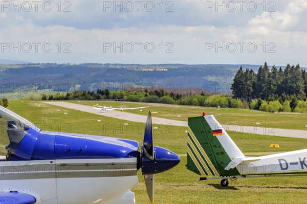 In the background runway and landing strip on it tow launching motorised aircraft towing glider