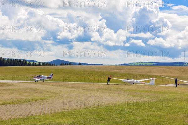 View of left single-engine light aircraft Robin DR400 as tow plane for right glider Glider pilots