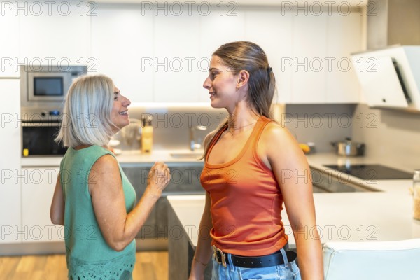 Senior woman and young adult sharing a lighthearted moment, gesturing and smiling in a modern