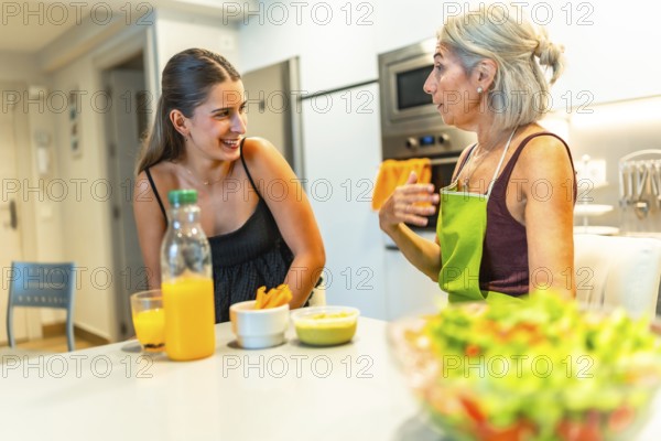 Senior woman wearing apron explaining recipe to her young adult daughter while preparing a healthy