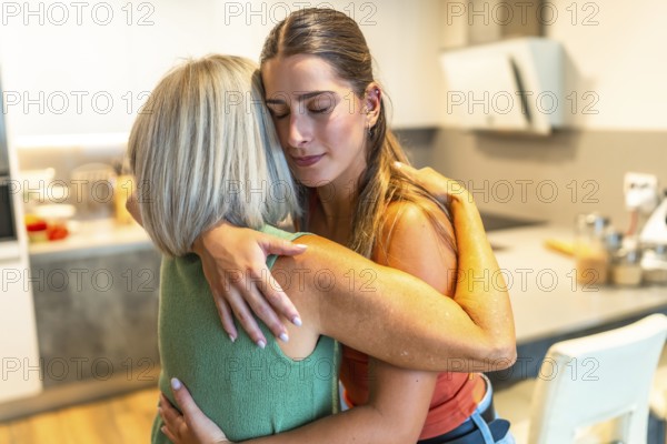 Adult daughter is embracing her senior mother, providing comfort and support in a heartwarming