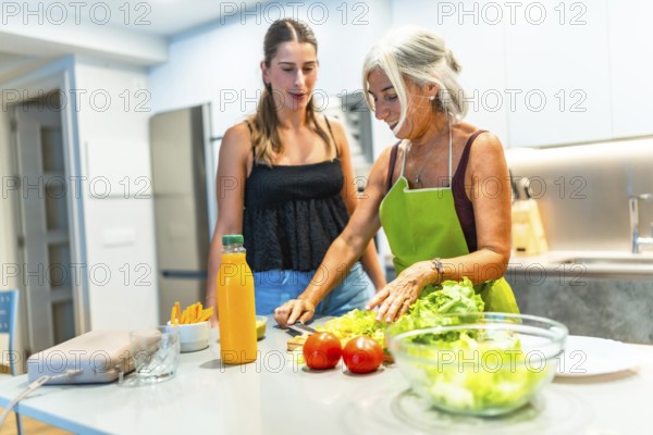 Mother and daughter preparing a healthy salad together in a modern kitchen, enjoying quality time