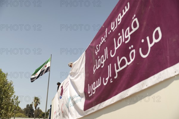 Relief workers unload boxes of medical aid provided by Qatar at Damascus International Airport,