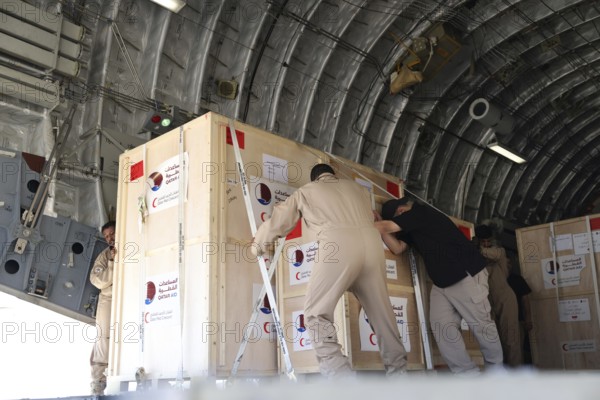 Members of the Qatari Air Force unload humanitarian aid supplies from a transport aircraft at