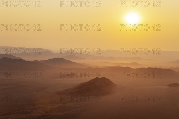 Arid plains and isolated mountain ridges at the edge of the Namib Desert. At sunrise. Aerial view