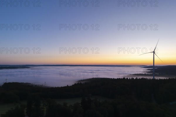 Single wind turbine with fog at sunrise along the horizon, near Schorndorf, Remstal,