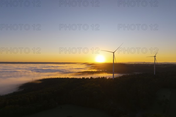 Wind turbines over foggy fields and hills at sunrise, near Schorndorf, Rems-Murr-Kreis,