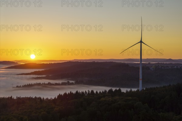Wind turbine at sunrise over a misty hilly landscape, near Schorndorf, Rems-Murr district,