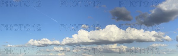 Panoramic photo of extended long wide stratocumulus white cloud cumulus clouds in front of bright