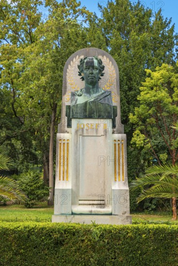 Bust of Joseph II on a monument, embedded in lush greenery and trees, spa garden Baden, Lower
