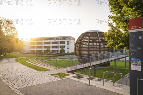 Modern architecture with a spherical building in the warm evening light, small town of Perle