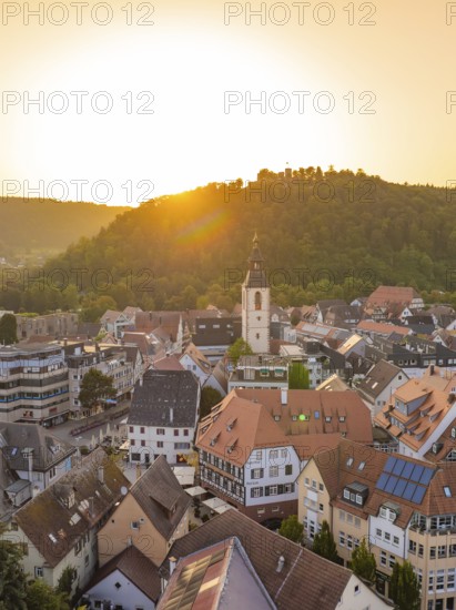 Sunny view of an old town with church and hills in the background at sunset, small town pearl