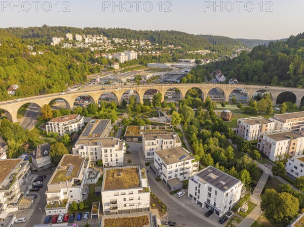 Aerial view of a viaduct in the middle of a residential area and the surrounding forests, small