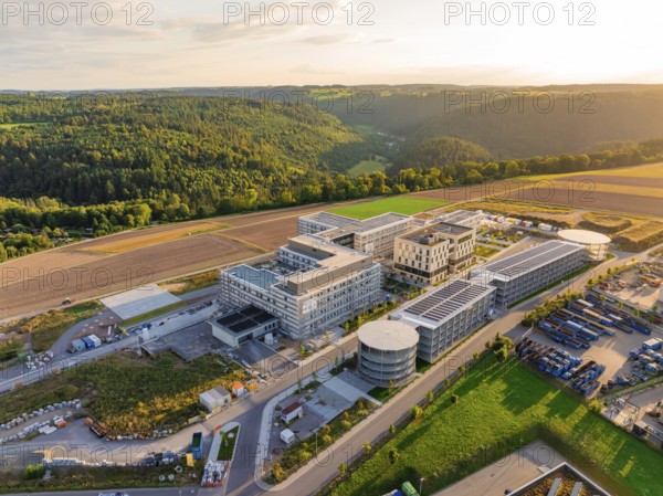 Large-scale building complex inspired by natural surroundings with hills and fields, new hospital