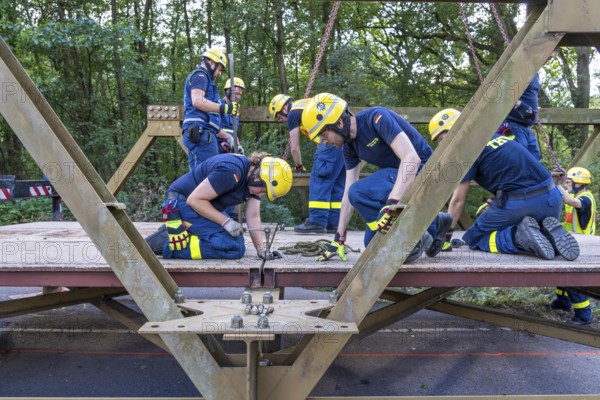 Construction of a temporary bridge over a slipped road crossing a stream, by the bridge