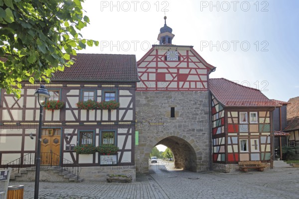 Historic Lower Tor with spire and clock and colourful half-timbered houses, Tor tor, town gate,
