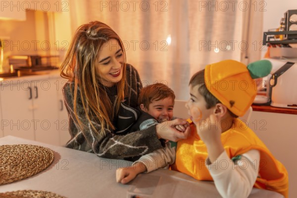 Smiling and playing together in the kitchen, a happy family enjoys halloween festivities while