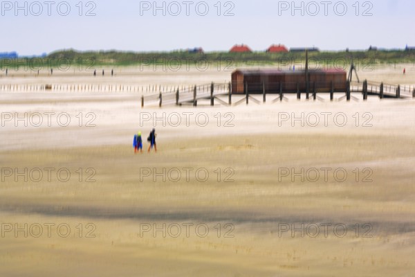 Strollers on the North Sea beach, pile dwelling, stilt house, wiping effect, long exposure, Sankt