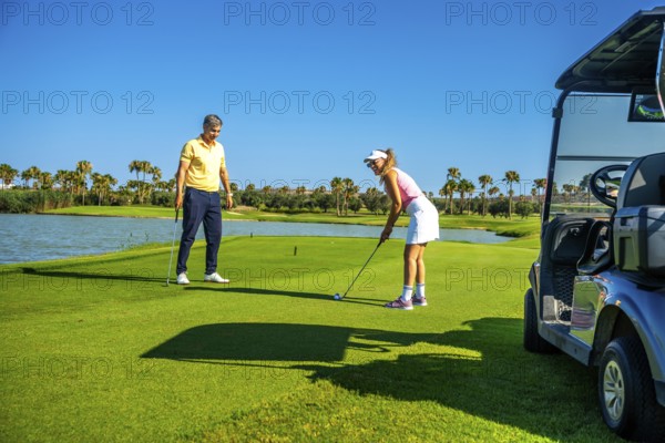 Couple playing golf on a beautiful sunny day, enjoying the sport and the stunning scenery