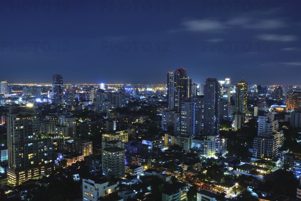 Bangkok's vibrant skyline at night, showcasing illuminated skyscrapers and bustling urban life in