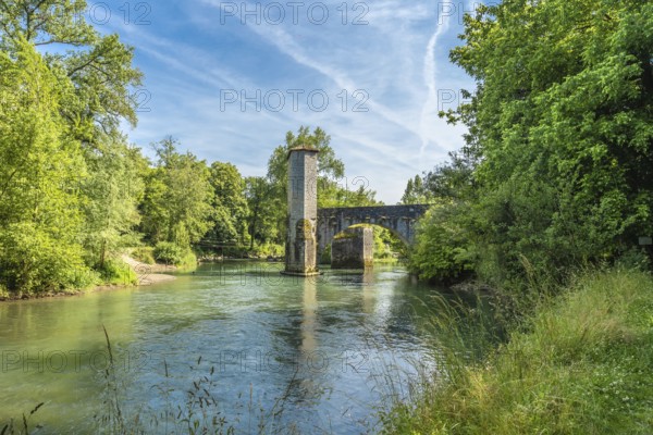 Scenic view of the historic stone bridge over the gave d'oloron river, surrounded by lush greenery,