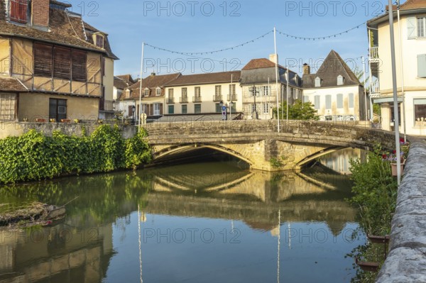Scenic view of the old stone bridge reflecting in the calm river during a sunny morning in the