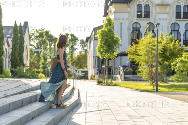 Young woman descending stairs in salies de bearn, a picturesque village in the pyrenees atlantiques