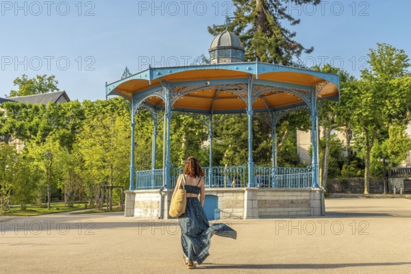 Tourist walking away from a bandstand in salies de bearn, a french village famous for its salt