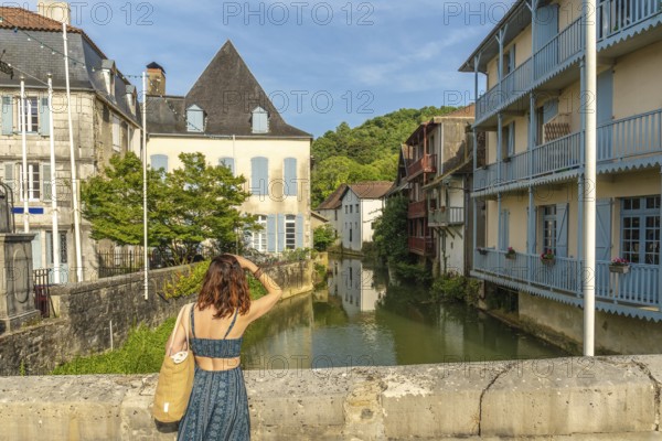 Tourist is enjoying the view of the saleys river and its colorful houses in the charming village of