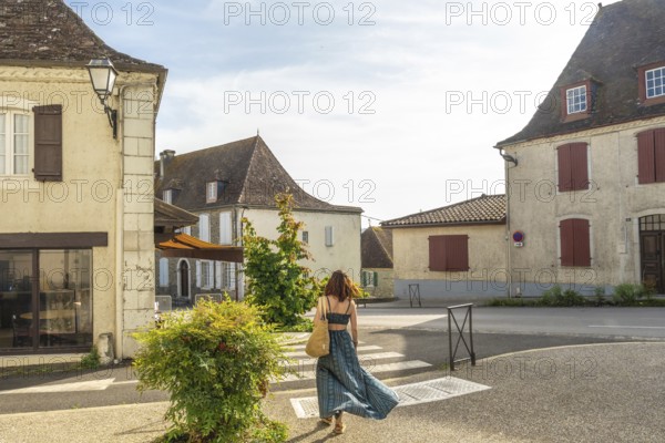 Tourist exploring charming streets of salies de bearn in france, enjoying summer vacation in a