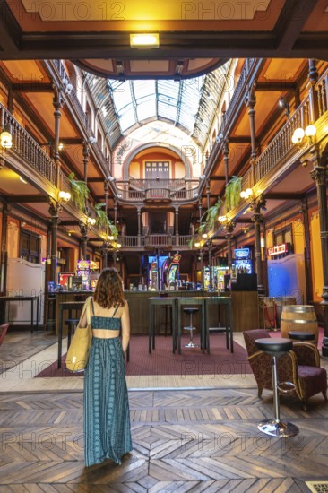 Tourist admiring the belle epoque architecture of the casino of salies de bearn, with its wooden