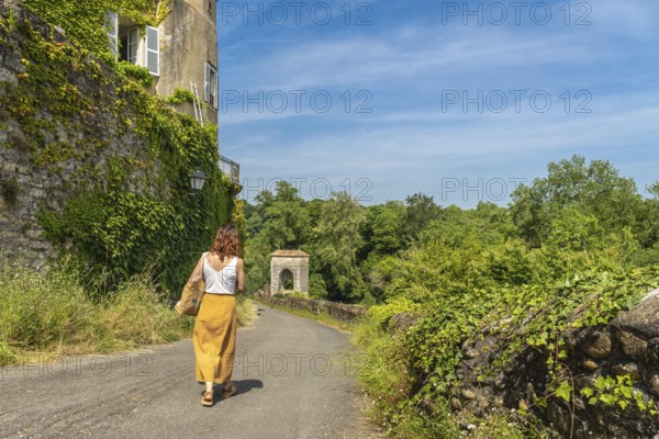 Tourist walking on a sunny day in sauveterre de bearn, france, exploring the medieval architecture