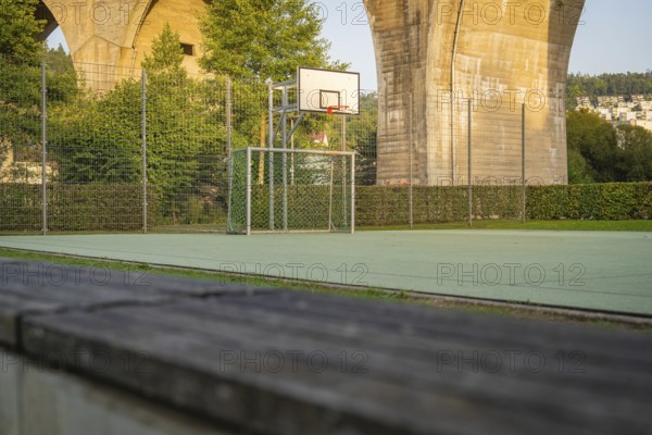 Outdoor basketball court under a large concrete bridge in an urban environment, Nagold, Calw